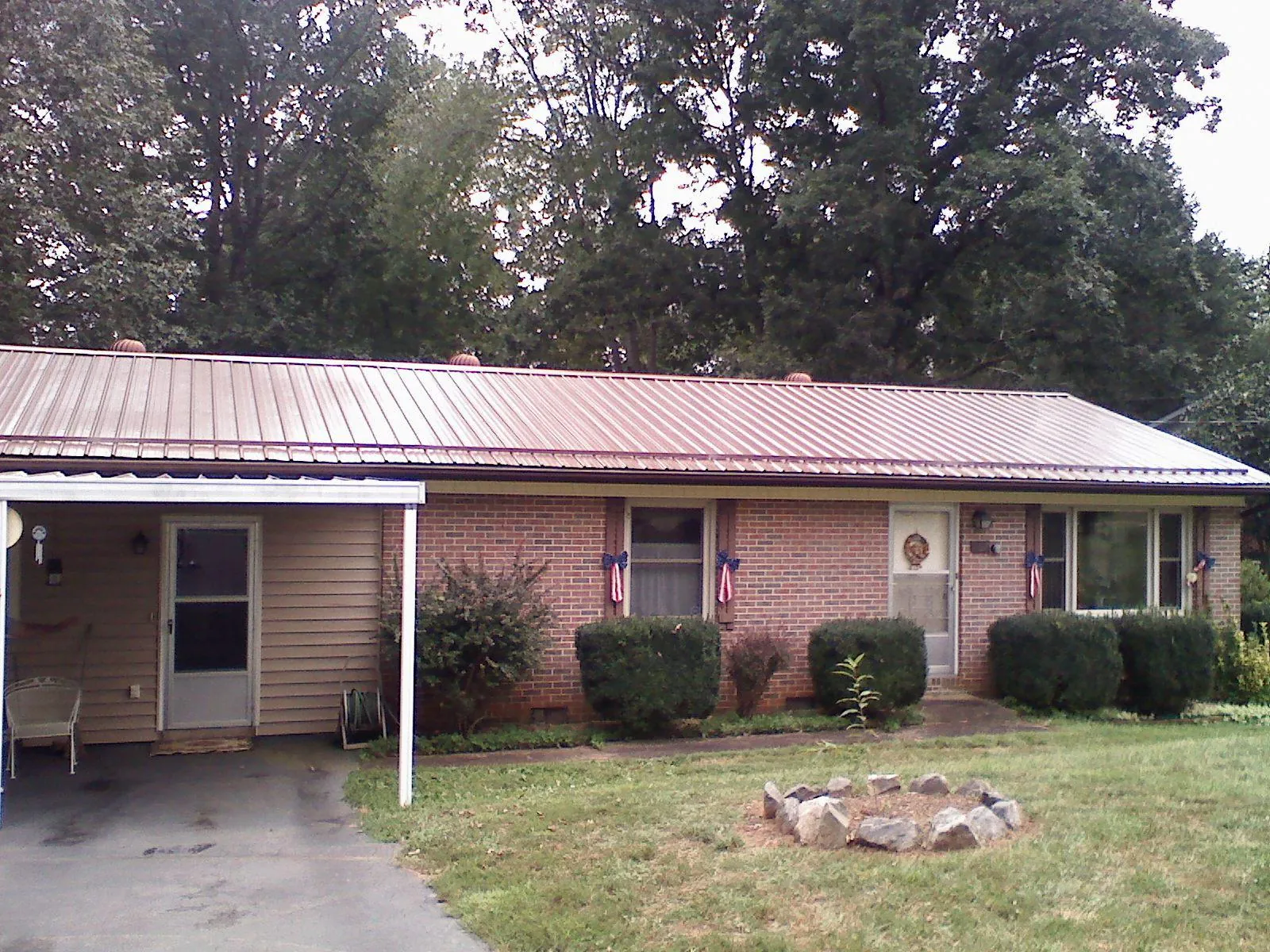 Bronze metal roof and carport on a brick ranch home — Roof Repair work by our crew in Clarks Hill